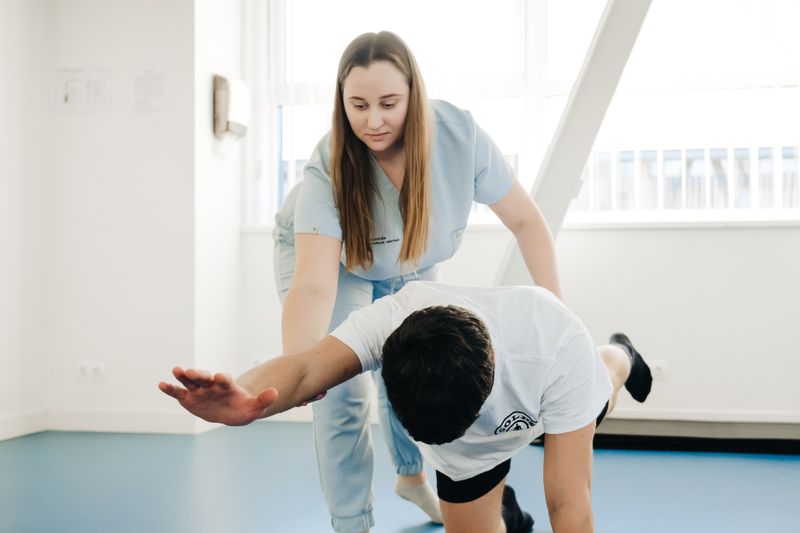 Fisioterapeuta guiando a paciente en ejercicios de rehabilitación