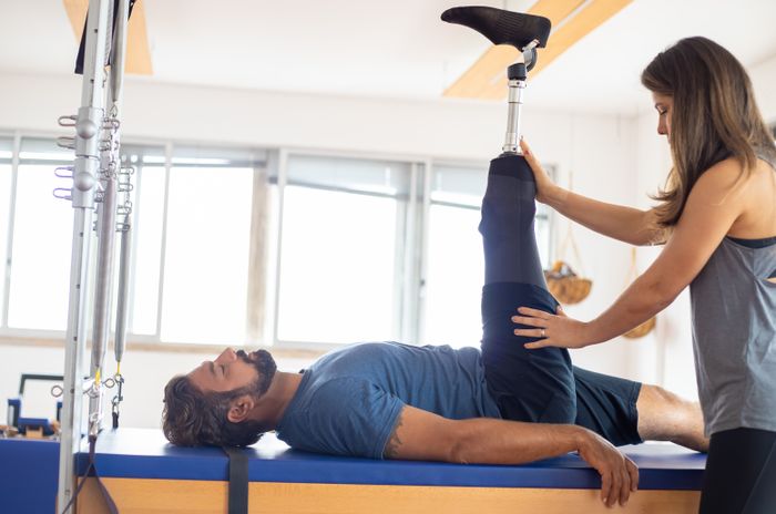 Terapia deportiva — entrenador asistiendo en ejercicio de rehabilitación