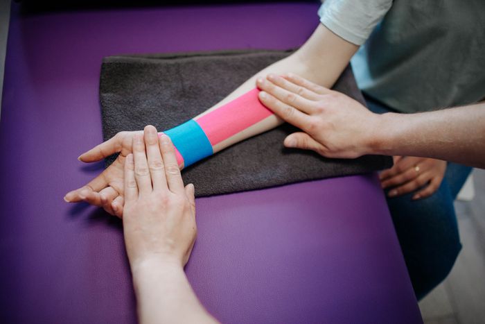 Terapia dermatofuncional — aplicación de vendaje kinesiológico en antebrazo
